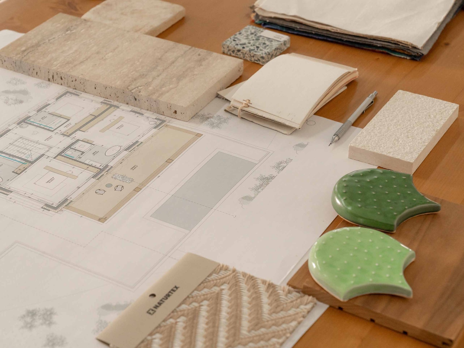 Material samples and plans on the studio desk